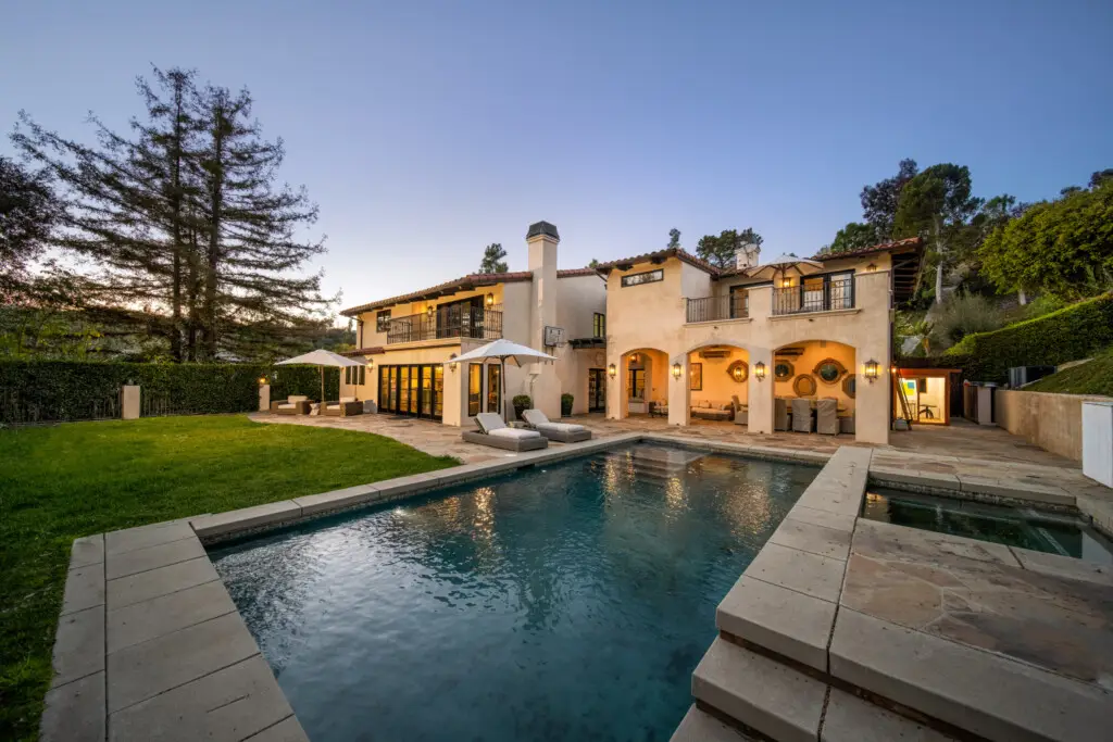 Should You Sell or Rent Your Home? 1 Luxurious villa with swimming pool, Outdoor patio area with swimming pool, lounge chairs, anLuxurious villa with swimming pool, outdoor seating, and well-maintained lawnd view of a luxurious seating, and well-maintained lawn