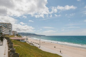 Beach scene with walking path, buildings, and the ocean