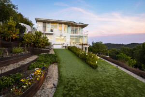 Property with a well-maintained lawn and a white house in the background.