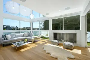 Modern living room with large windows, fireplace, and comfortable seating area