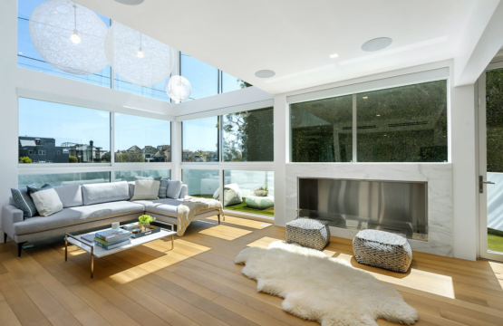 Modern living room with large windows, fireplace, and comfortable seating area