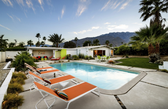 House of the Sun in Palm Springs by Open Air Homes - Outdoor pool area with a modern house, palm trees, and a mountain backdrop