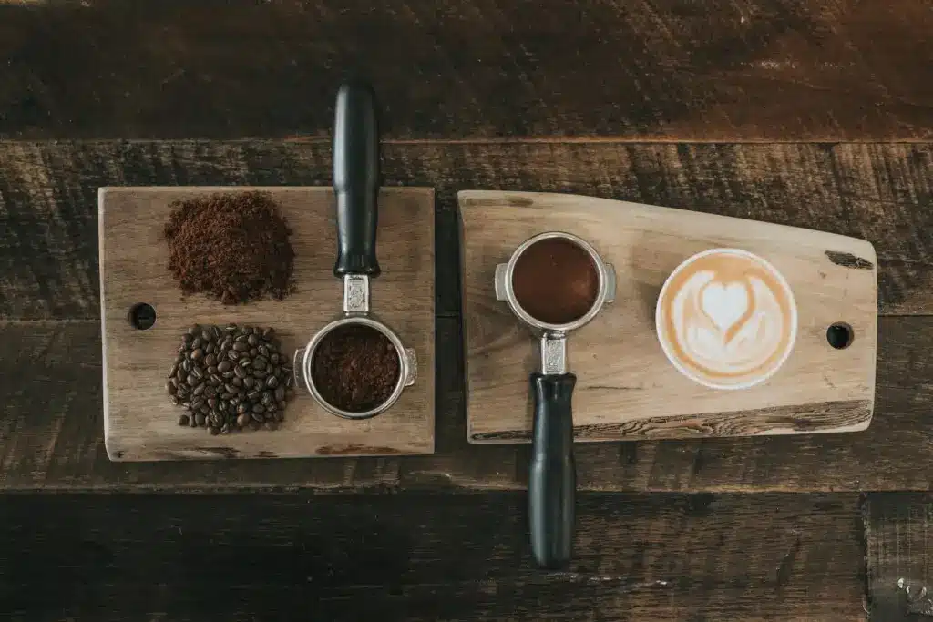 The Best Coffee Options for your Short-Term Rental 2 Coffee setup with coffee beans, ground coffee, and a cappuccino on a wooden surface