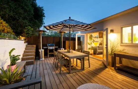 Outdoor patio area with a dining table, chairs, and umbrella, leading to a living room - Experience Lookout Mountain Paradise: A Hidden Gem in Laurel Canyon - by Open Air Homes