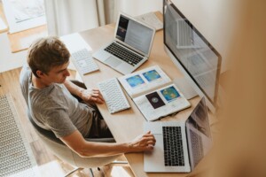 Person working at a desk with laptops.