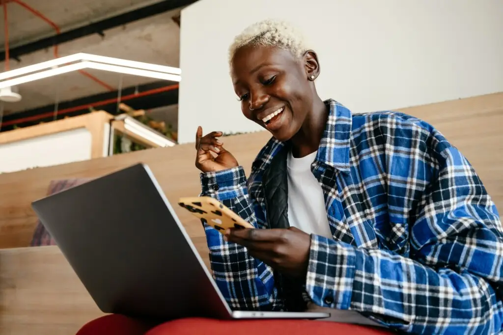 Simplicity in Communication: Why We Embrace Texting Our Guests at Open Air Homes 2 Person smiling while using a laptop, representing a satisfied guest booking a stay with Open Air Homes.