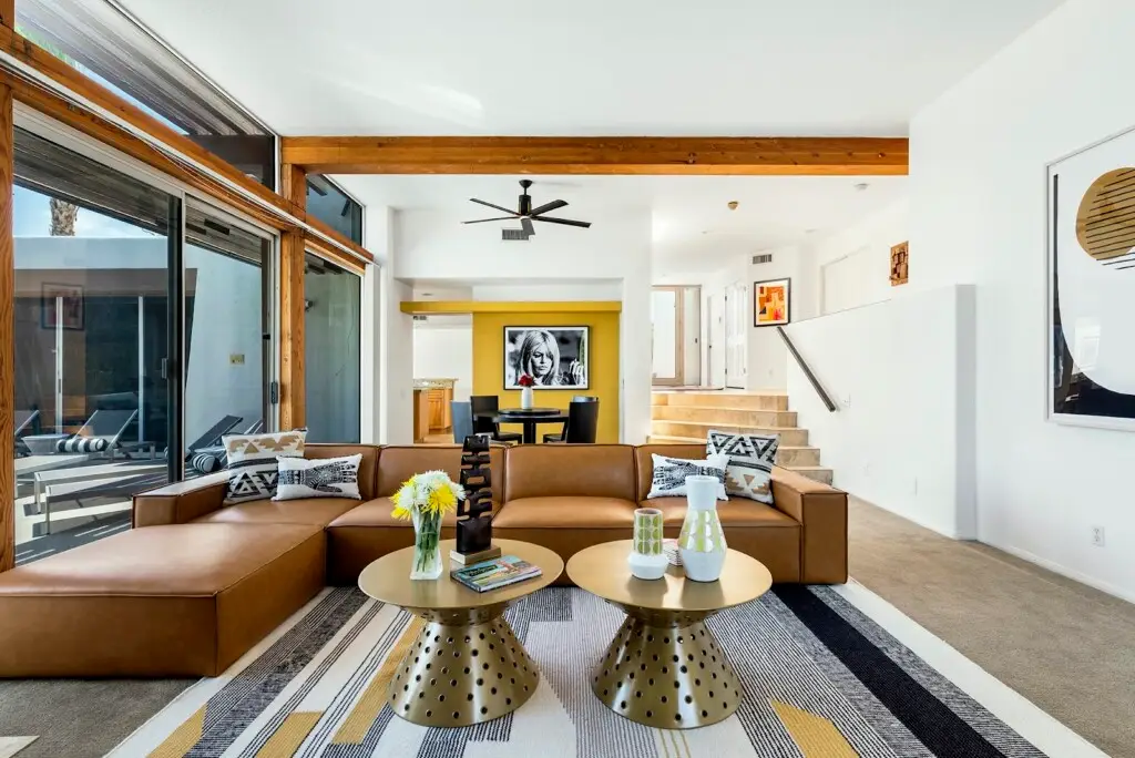 Stylish and modern living room with a large sectional sofa and bright, open layout - by Open Air Homes.