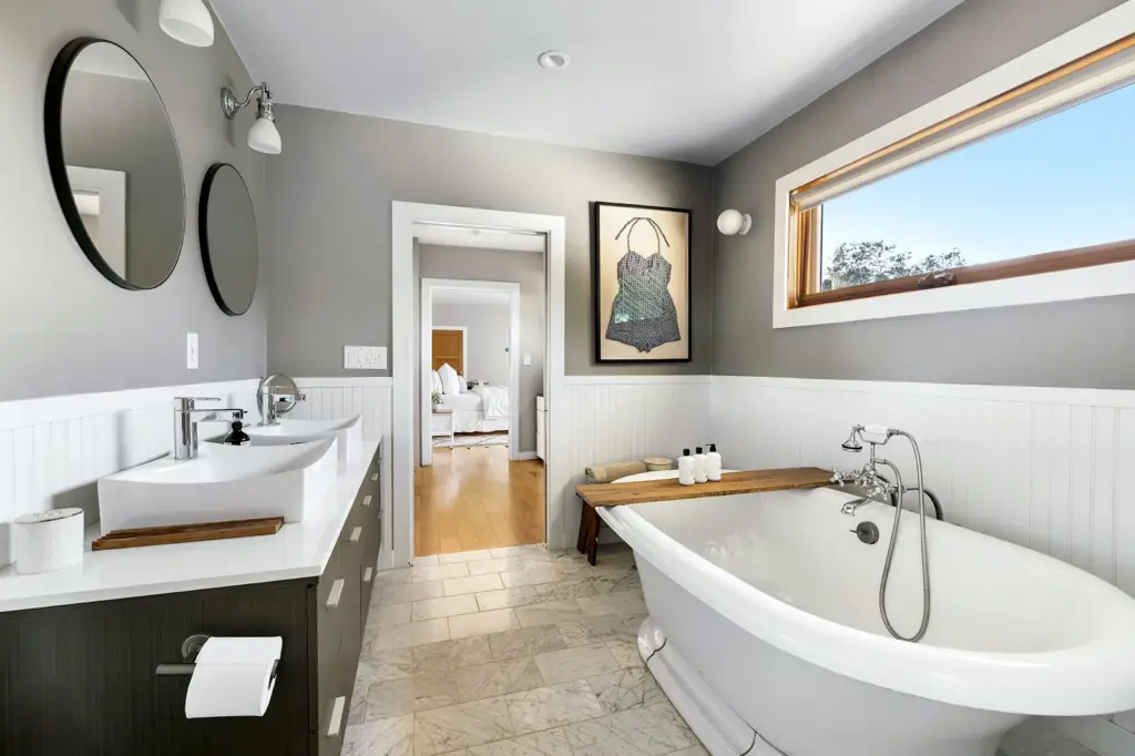 Bathroom with a freestanding bathtub, double sink, and modern design – by Open Air Homes.