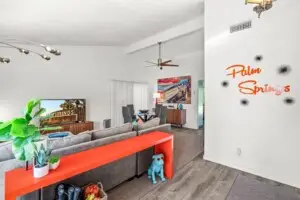 Modern living room with 'Palm Springs' wall art at The Blue Door Bungalow – by Open Air Homes.