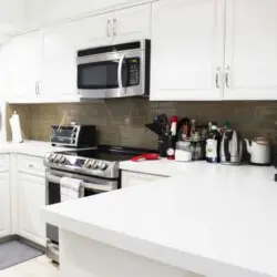 Modern kitchen with white design and appliances at Desert Falls - by Open Air Homes