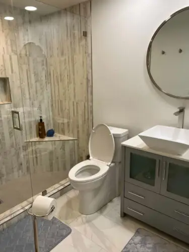 Bathroom with toilet, vanity, and glass shower at Desert Falls by Open Air Homes.