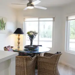 Dining area with round table, chairs, and ceiling fan at Desert Falls - by Open Air Homes