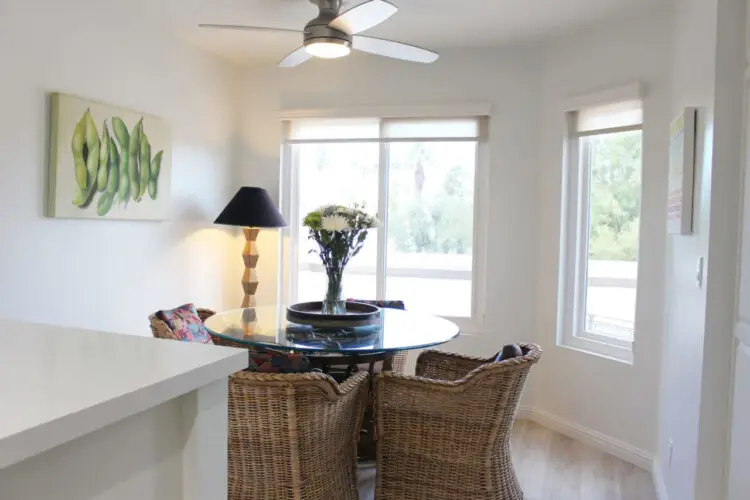 Dining area with round table, chairs, and ceiling fan at Desert Falls - by Open Air Homes