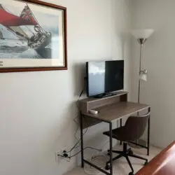 Small desk with chair, monitor, and lamp in a room at Desert Falls by Open Air Homes.