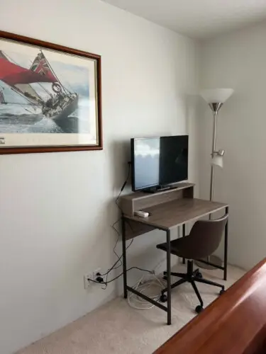 Small desk with chair, monitor, and lamp in a room at Desert Falls by Open Air Homes.