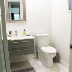 Bathroom with toilet, vanity, and mirror at Desert Falls by Open Air Homes.