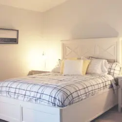 Bedroom with large bed, nightstands, and lamp at Desert Falls by Open Air Homes.