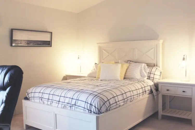 Bedroom with large bed, nightstands, and lamp at Desert Falls by Open Air Homes.