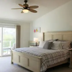 Bedroom with large bed, nightstands, and balcony access at Desert Falls by Open Air Homes.