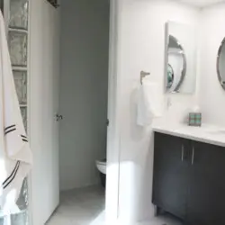 Bathroom with vanity, mirror, and towel rack at Desert Falls by Open Air Homes.