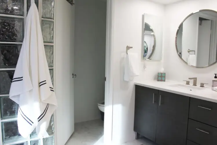 Bathroom with vanity, mirror, and towel rack at Desert Falls by Open Air Homes.