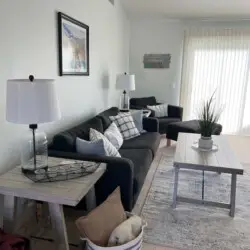 Living room with sofa, coffee table, and decor at Desert Falls - by Open Air Homes