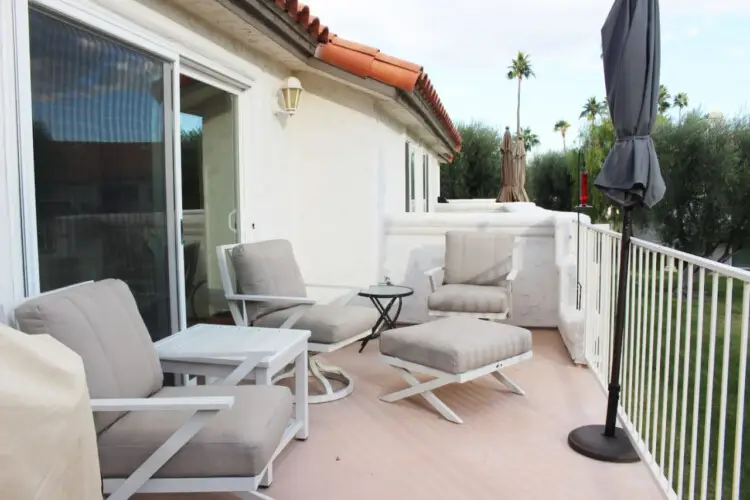 Outdoor seating area with chairs and table on a balcony at Desert Falls - by Open Air Homes