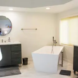 Bathroom with freestanding bathtub, vanity, and mirror at Desert Falls by Open Air Homes.