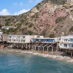 Oceanfront houses on stilts along the coastline.