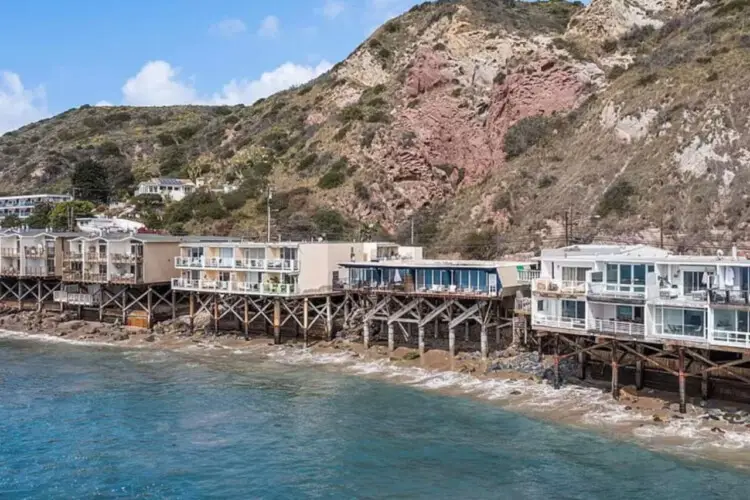 Oceanfront houses on stilts along the coastline.