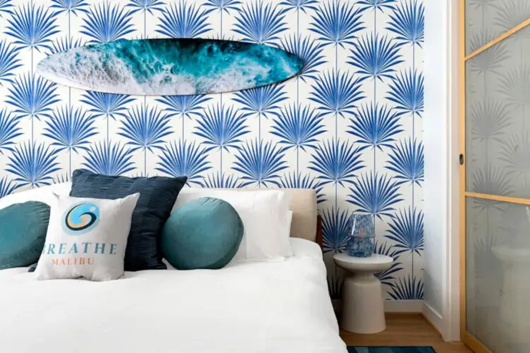 Bedroom with beach-inspired design and surfboard wall decoration at Breathe Malibu - Ocean Front Condo w/ Beach Access by Open Air Homes.