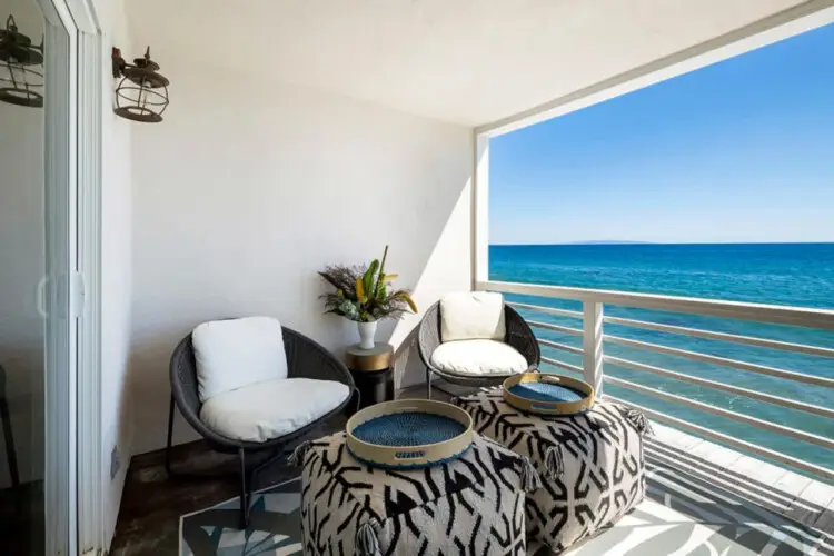 Balcony with seating area overlooking the ocean at Breathe Malibu - Ocean Front Condo w/ Beach Access by Open Air Homes.