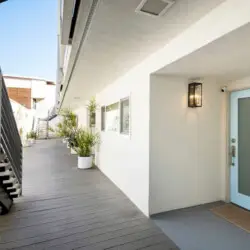 Exterior walkway with potted plants leading to a door at Breathe Malibu - Ocean Front Condo w/ Beach Access - by Open Air Homes