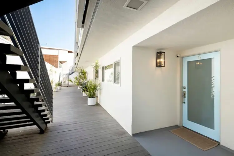 Exterior walkway with potted plants leading to a door at Breathe Malibu - Ocean Front Condo w/ Beach Access - by Open Air Homes