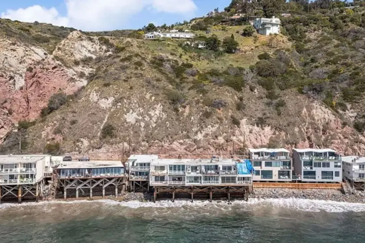 Oceanfront houses on stilts along the coastline at Breathe Malibu - Ocean Front Condo w/ Beach Access by Open Air Homes.