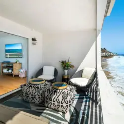 Balcony with ocean view and outdoor seating at Breathe Malibu Ocean Front Condo - by Open Air Homes.