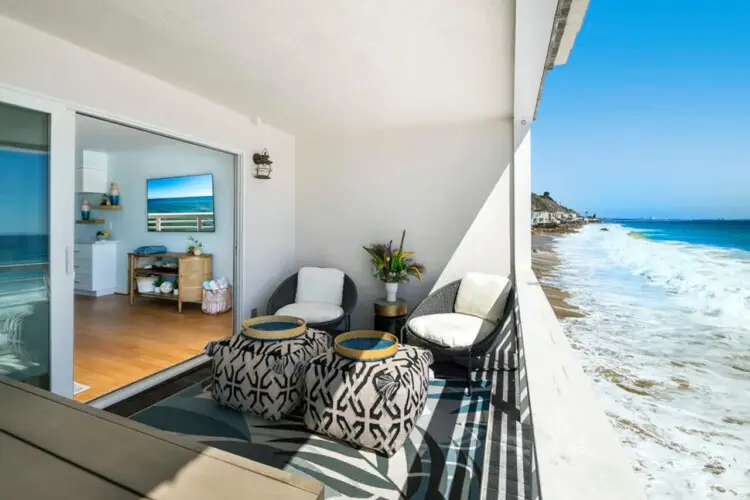 Balcony with ocean view and outdoor seating at Breathe Malibu Ocean Front Condo - by Open Air Homes.