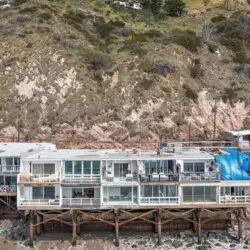 Oceanfront homes on stilts along the shoreline at Breathe Malibu - Ocean Front Condo w/ Beach Access by Open Air Homes.