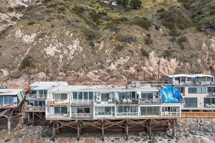 Oceanfront homes on stilts along the shoreline at Breathe Malibu - Ocean Front Condo w/ Beach Access by Open Air Homes.