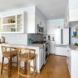 Modern kitchen with white cabinetry, stainless steel appliances, and kitchen island at Breathe Malibu - Ocean Front Condo w/ Beach Access by Open Air Homes.