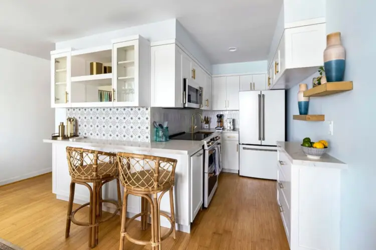 Modern kitchen with white cabinetry, stainless steel appliances, and kitchen island at Breathe Malibu - Ocean Front Condo w/ Beach Access by Open Air Homes.