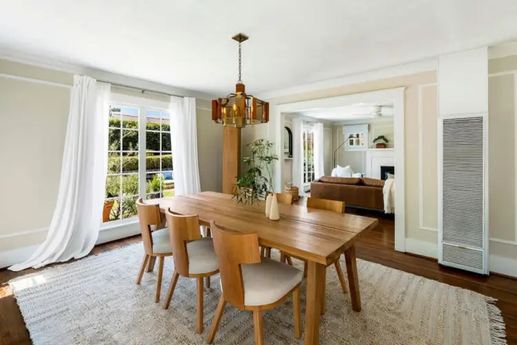 Dining area with wooden table and chairs at Charming Walk Street Hideaway in Venice Beach by Open Air Homes.