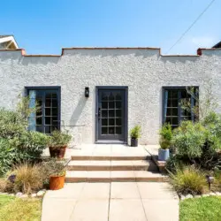 Front exterior of Charming Walk Street Hideaway with pathway and greenery in Venice Beach by Open Air Homes.