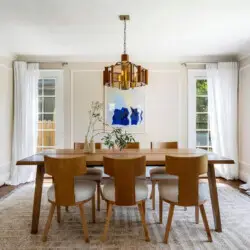 Dining room with wooden table, chairs, and chandelier at Charming Walk Street Hideaway in Venice Beach by Open Air Homes.