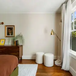 Bedroom with white ceiling, bed, and drBedroom with white ceiling, bed, brown bedding, wooden dresser, and window at Charming Walk Street Hideaway in Venice Beach by Open Air Homes.esser at Charming Walk Street Hideaway - by Open Air Homes