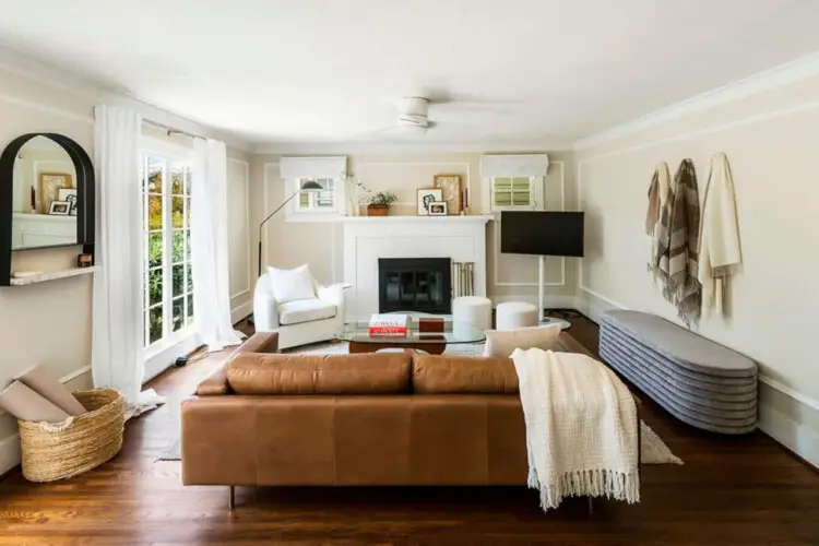 Living area with leather sofa, fireplace, and wall-mounted TV at Charming Walk Street Hideaway in Venice Beach by Open Air Homes.