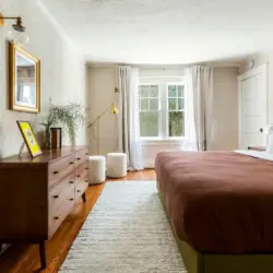 Bedroom with wooden dresser, bed, and window at Charming Walk Street Hideaway in Venice Beach by Open Air Homes.