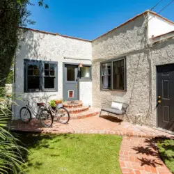 Exterior of Charming Walk Street Hideaway by Open Air Homes with a patio, bicycles, and a well-kept lawn.