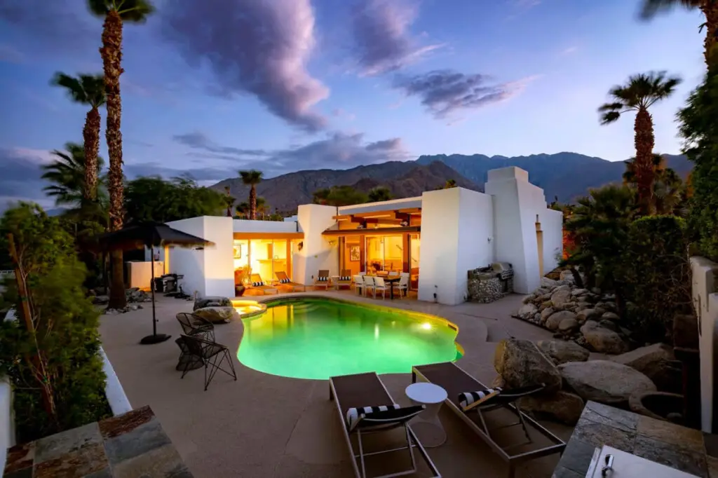Sunsplash by Open Air Homes - Pool, Mountain Views 5 Luxurious pool area with modern house, palm trees, and mountain view in a luxury vacation rental – Open Air Homes.
