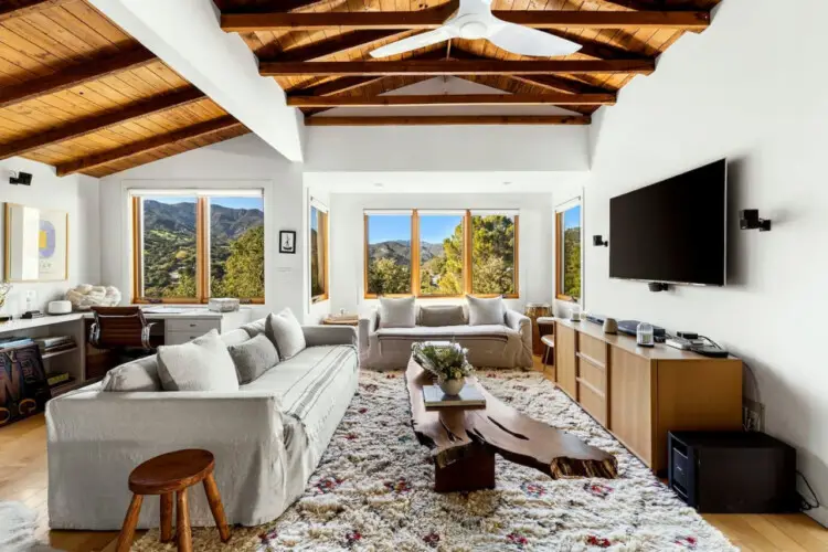 Spacious living room at Hillside Hideaway w/ Spa in Topanga Canyon with scenic hill views by Open Air Homes.